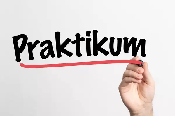 Human hand writing Praktikum on whiteboard