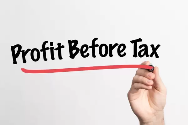 Human hand writing Profit Before Tax on whiteboard