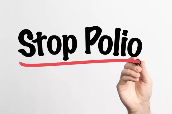 Human hand writing Stop Polio on whiteboard