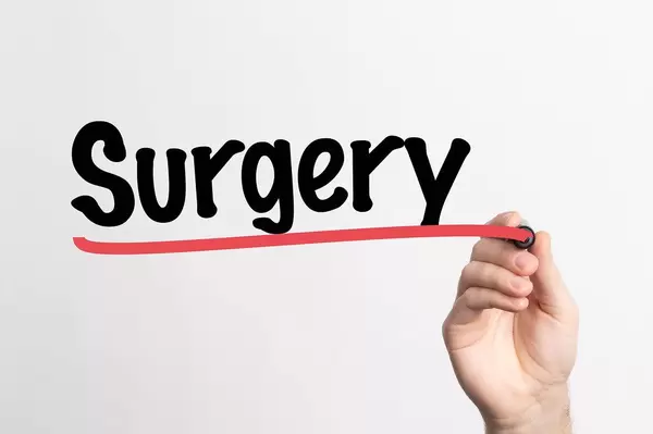 Human hand writing Surgery on whiteboard