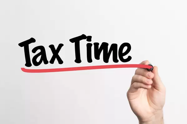 Human hand writing Tax Time on whiteboard