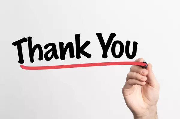 Human hand writing Thank You on whiteboard