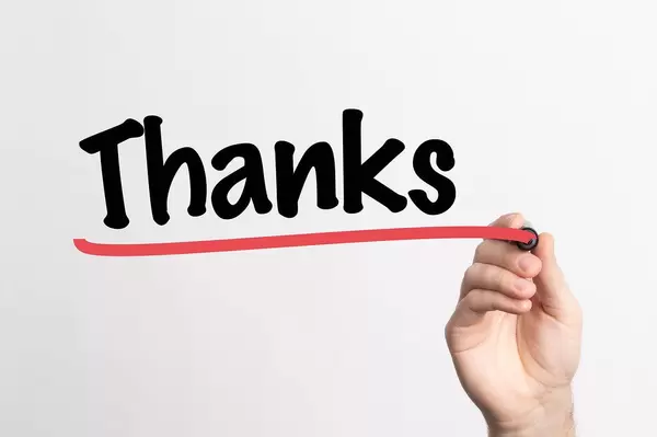 Human hand writing Thanks on whiteboard