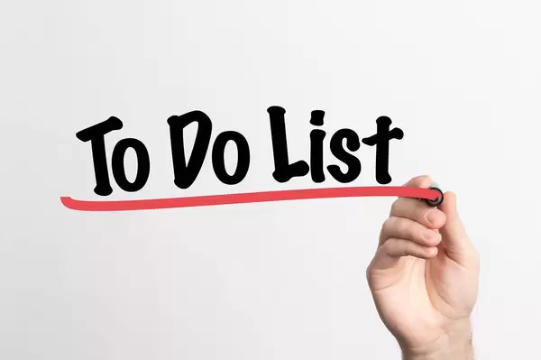 Human hand writing To Do List on whiteboard
