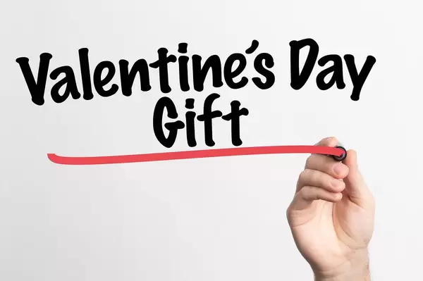 Human hand writing Valentine's Day Gift on whiteboard