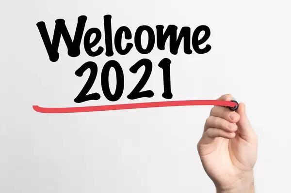 Human hand writing Welcome 2021 on whiteboard