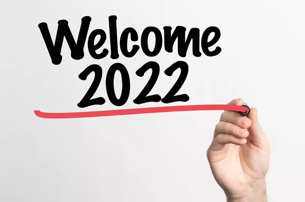 Human hand writing Welcome 2022 on whiteboard