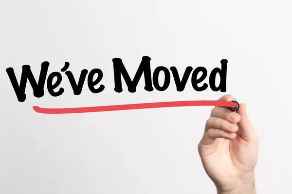 Human hand writing We've Moved on whiteboard