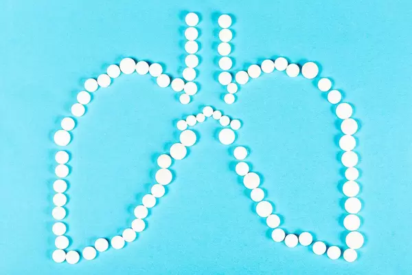 Human lungs made of pills on a blue background