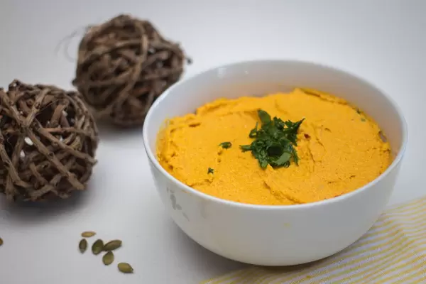 Hummus aus Kürbis in einer Schüssel mit Petersilie verziert