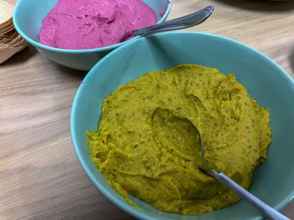 Humus mit roter Beete und Curry in Schälchen