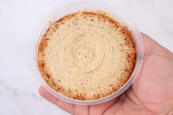 Humus with Olives in the bowl in the hand (Flip 2019)