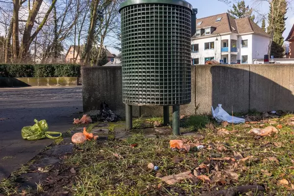 Hundekot-Beutel verstreut um eine Mülltonne