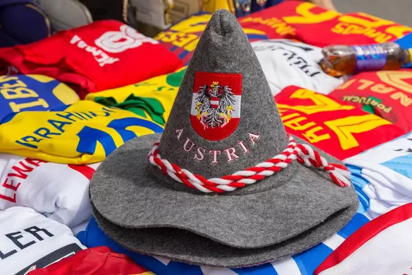 Hut mit dem Schriftzug Austria und österreichischem Wappen und unterschiedliche Trikots