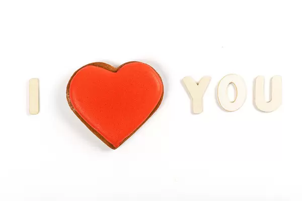 I love you - made of wooden letters and red gingerbread heart on white