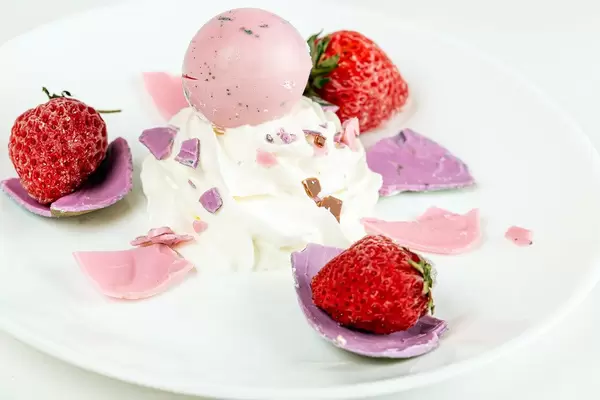 Ice cream dessert with fresh strawberries, purple and pink chocolate