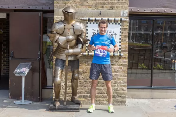 Ich neben einer Ritterrüstung mit London Marathon Startnummer in Händen