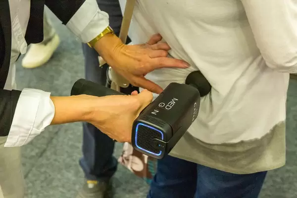IFA-Messebesucher testen das MediGun Vibrationsmassagegerät zur Lockerung von Muskeln, Verkrampfungen und Verspannungen