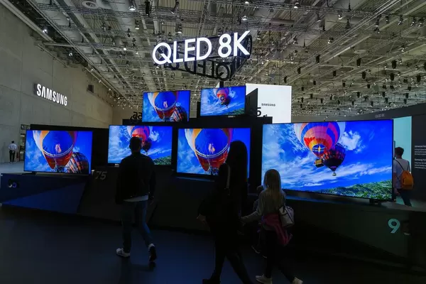 IFA-Messebesucher vor großen Fernsehbildschirmen von Samsung QLED 8K mit AI-Upscaling-Funktion