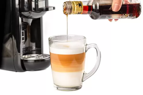 In a cup of coffee latte pour the syrup from the bottle