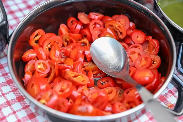 In Scheiben geschnittene, kleine Tomaten in einem Kochtopf