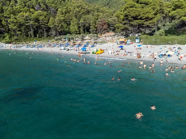 In the footsteps of Mamma Mia! movie: tourists on famous Kastani beach on Skopelos seen from the sea