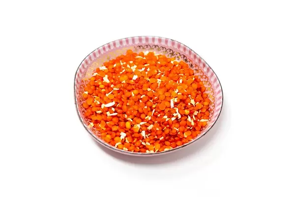 Indische Linsenmischung "Kokos-Dahl-Linselei" von Davert, mit Kokosraspeln und geschälten Linsen, in einer rose Schale