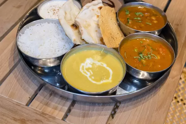 Indisches Mittagessen serviert in Schälchen mit Reis und Fladenbrot