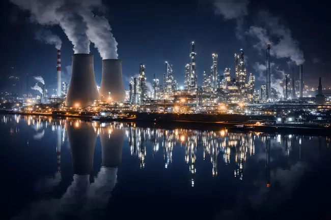 Industrielle Raffinerie-Skyline bei Nacht mit Reflexionen