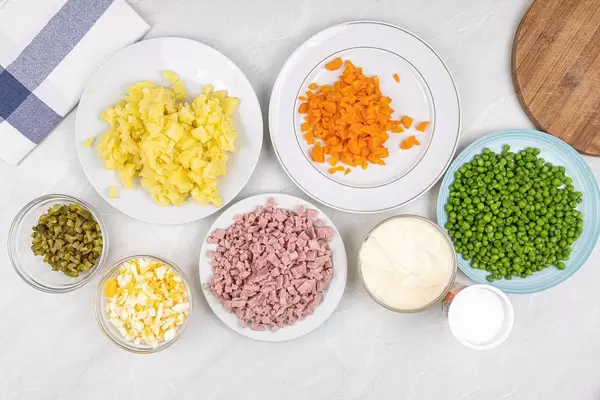 Ingredients on the plates ready for mixing Russian Salad