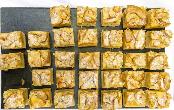 Ins Würfel geschnittene Apfel-Mandel-Kuchen auf schwarzem Probiertablett auf dem BarCamp in Bonn