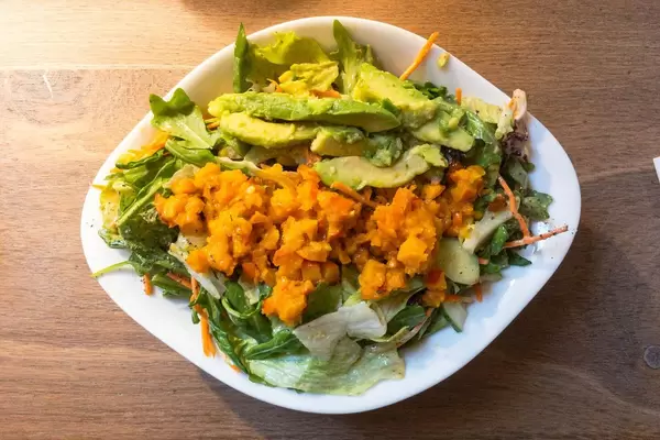 Insalata Julia: roasted pumpkin squares, arugula, corn, cucumbers, carrots, avocado, cherry tomatoes, dressing