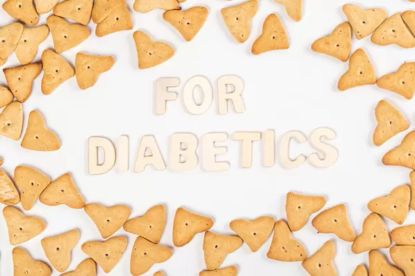 Inscription for diabetics made of wooden letters on white with cookie frame