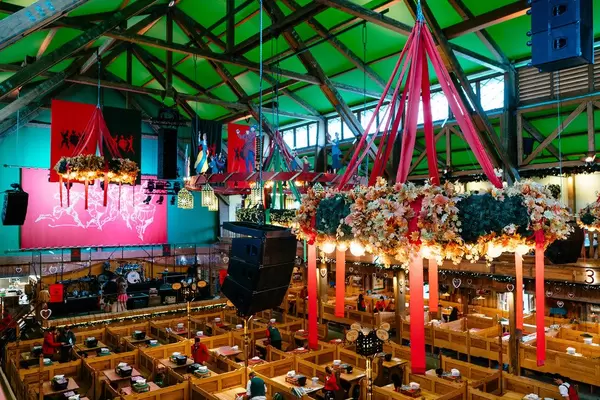 Inside of the tent of Oktoberfest with a huge Chandelier full of flowers