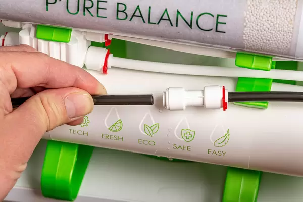 Installation of water purification filters under kitchen sink in cupboard, clear water concept