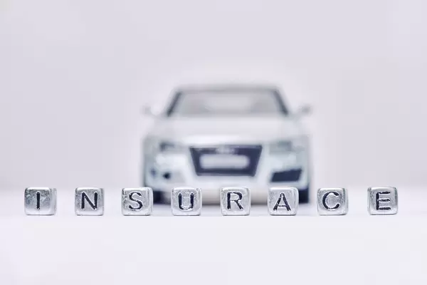 Insurance word made of miniature blocks and automobile toy