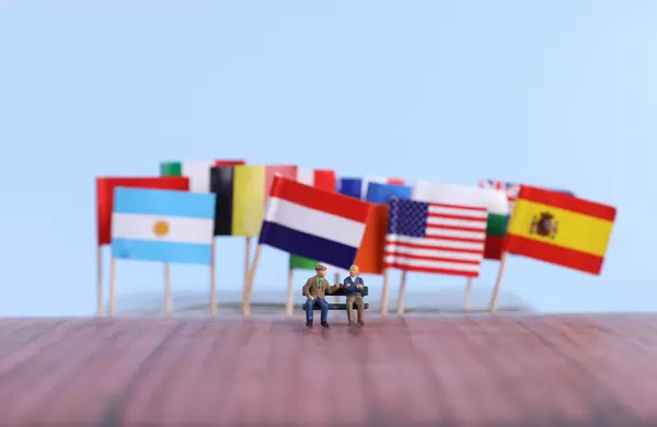 International flags and two elderly people sitting on the bench