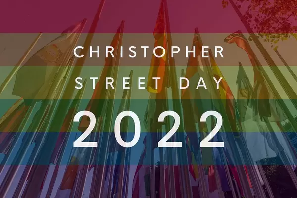 International flags on flagpoles behind rainbow flag colors, with the picture Titel "Christopher Street Day 2022" to celebrate diversity