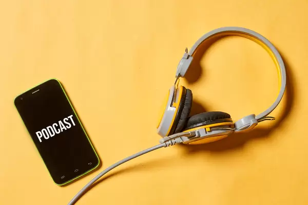 Internet radio media concept - headphones and smartphone on yellow background
