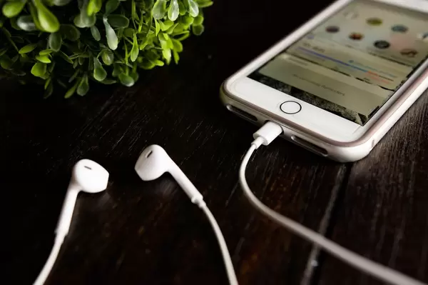 Iphone and earphones on a wooden table