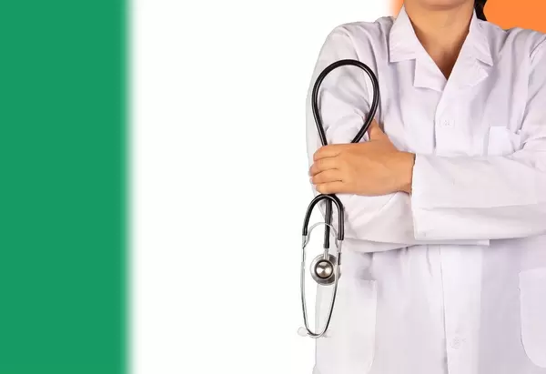 Irisches Gesundheitssystem symbolisiert durch die Nationalflagge und eine Ärztin mit Stethoskop in der Hand