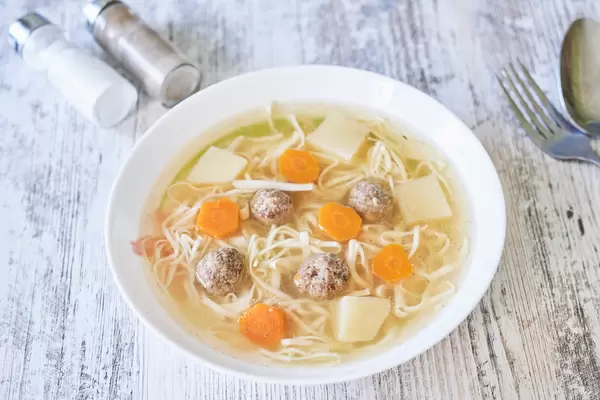 Italian meatball soup on wooden table