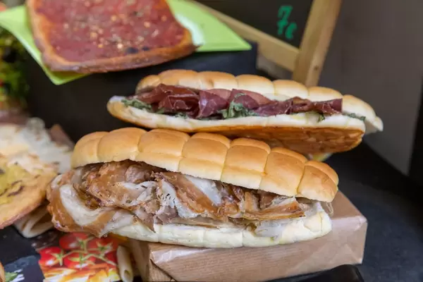 Italian sandwiches with porcetta, soft cheese, dtied tomatos and rocket salad