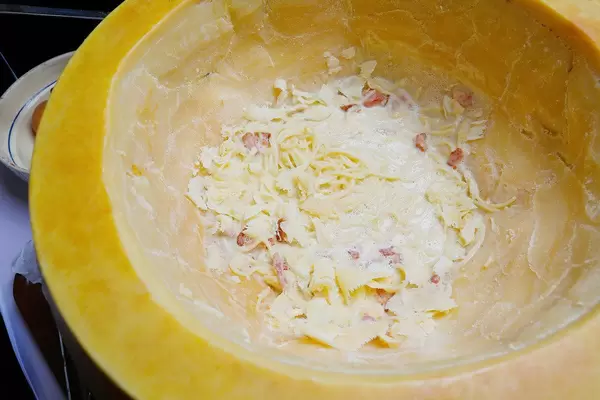 Italienische Küche: servierfertige Spaghetti mit Speck im Parmesankäse-Laib