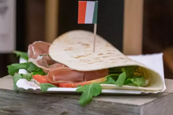 Italienisches Essen: Piadina Romangola mit Parmaschinken, Rucola, Frischkäse, Pesto, Tomaten und Mozzarella