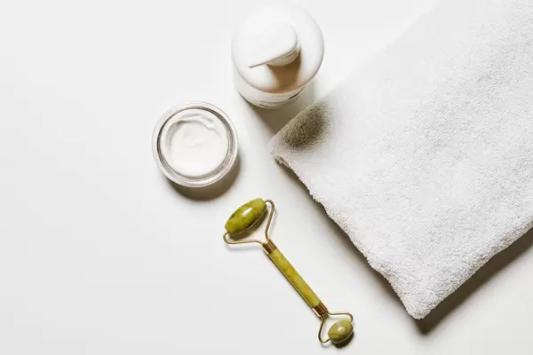 Jade face roller and spa creams for beauty facial massage therapy