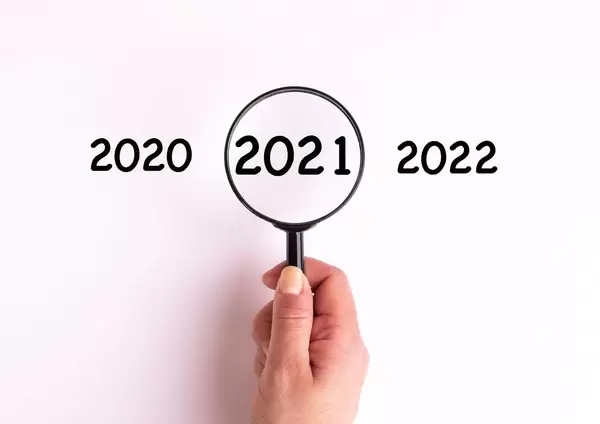 Jahreszahl 2021 auf weißer Oberfläche unter einer Lupe dargestellt