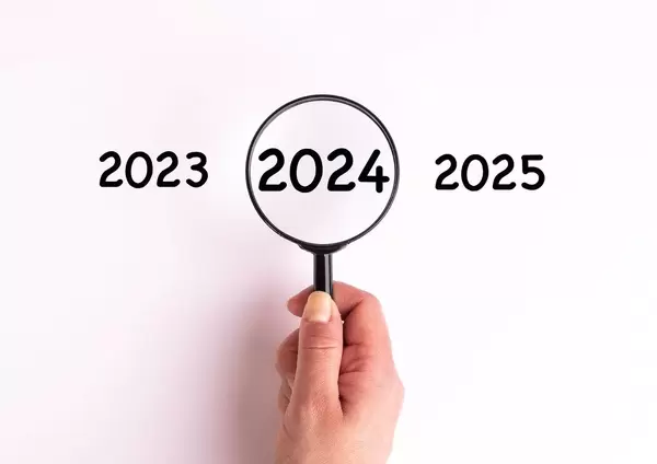 Jahreszahl 2024 auf weißer Oberfläche unter einer Lupe dargestellt