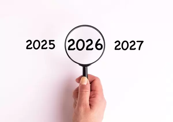 Jahreszahl 2026 auf weißer Oberfläche unter einer Lupe dargestellt
