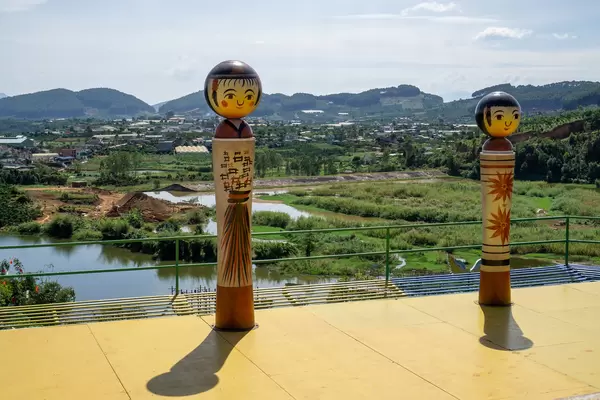 Japanese Themed Characters on a Sun Terrace with View of Mountains and a Village in the Background in Dalat, Vietnam